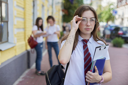 戴眼镜的肖像女学生少年系带背包的白色 T 恤