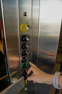 电梯按钮摄影照片_女人手放在电梯按钮上近距离观看