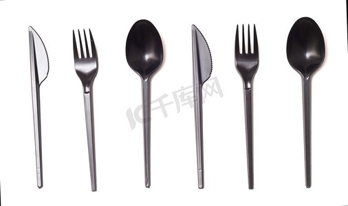 重复黑色塑料一次性刀、勺子和叉子，隔离在白色、顶视图上。