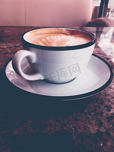 卡布奇诺咖啡在自助餐厅吃早餐，咖啡杯在巴黎咖啡馆的桌子上