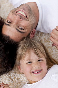 父亲和女儿在地板上头靠在一起的肖像