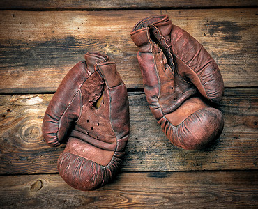 古代体育运动摄影照片_非常旧的皮革棕色拳击手套