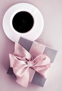 粉红色背景的豪华礼盒和咖啡杯，浪漫假期和生日惊喜的平面设计