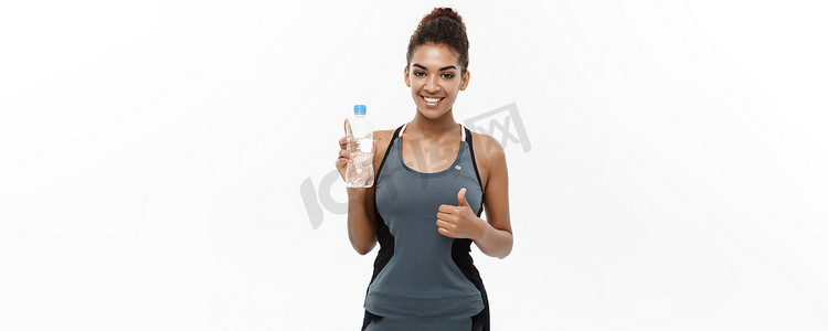 健康和健身概念-穿着运动服的美丽的非洲裔美国女孩在锻炼后拿着塑料水瓶。