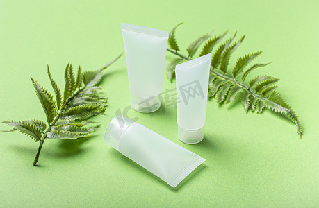 护肤品绿色背景摄影照片_护肤有机美容产品瓶、绿色背景植物叶
