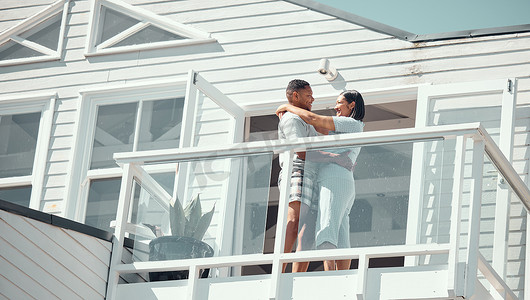 穿着睡衣的爱年轻的混血情侣在新家的阳台上跳舞或在度假享受蜜月时分享浪漫的时刻