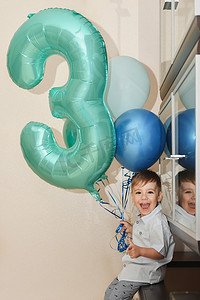男孩的数字 3 和他生日的气球