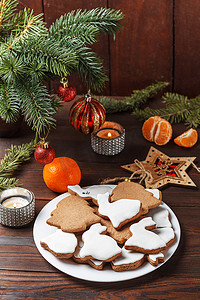美味的自制圣诞饼干，形状是兔子和圣诞树，木桌上装饰着新年装饰。