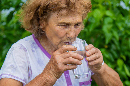 奶奶用杯子喝水。
