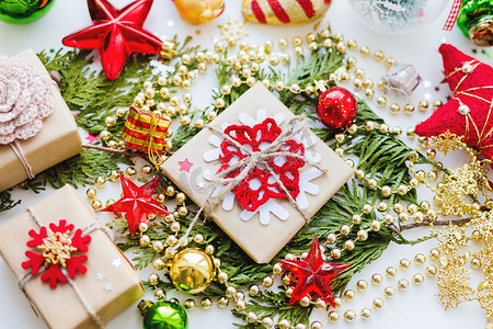 圣诞节和新年背景与崖柏树枝、装饰品和用雪花牛皮纸包裹的礼物。