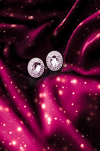 深红色丝绸上的奢华钻石耳环，雪光闪闪，节日冬季魔法珠宝礼物