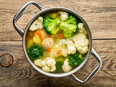 大金属锅，配有美味的蔬菜和肉丸热汤、花椰菜、西兰花、胡萝卜、辣椒、土豆、健康饮食食品、顶视图