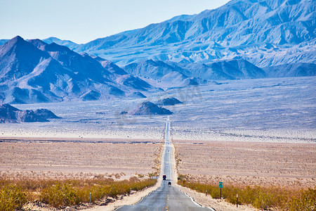 通往沙漠山脉的漫长无尽道路的景色