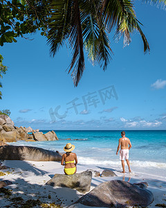 兰乔摄影照片_塞舌尔普拉兰岛安斯乔吉特，一对年轻夫妇在塞舌尔的热带海滩上享受豪华假期。