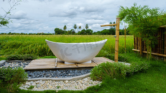在泰国一家寄宿家庭度假，外面有白色浴缸，有绿色的稻田