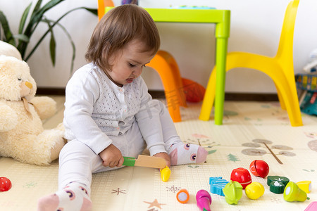 快乐有趣的孩子卷发女婴与​​益智玩具积木花。