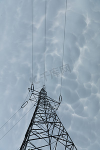 暴风漩涡摄影照片_暴风云背景下的钢制输电杆。