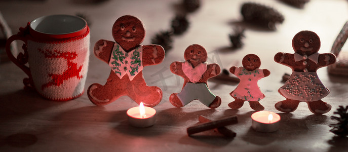 圣诞姜饼人蜡烛，配有肉桂星、松枝、木地板上的圣诞球