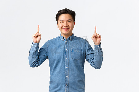 身穿蓝色衬衫、面带微笑、自豪而快乐的亚洲男模发布公告，指着横幅，推荐购买产品、点击链接、电子商务和广告概念
