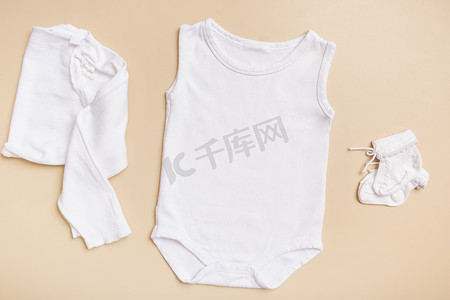 白色婴儿紧身衣模型，用于米色背景上的徽标、文字或设计，具有衣服顶视图