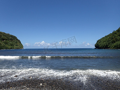 夏威夷图摄影照片_海浪拍打着霍诺马努公园的黑沙滩