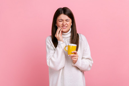 患病的黑发妇女在喝热或冷饮料后牙齿敏感，蛀牙。
