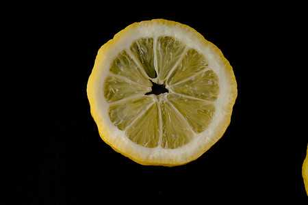 上半圆半圆摄影照片_五片柠檬片在孤立的黑色背景上排成半圆