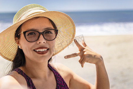 海滩美女摄影照片_漂亮的女孩在海滩上自拍，快乐的漂亮女孩在海滩上自拍，度假概念