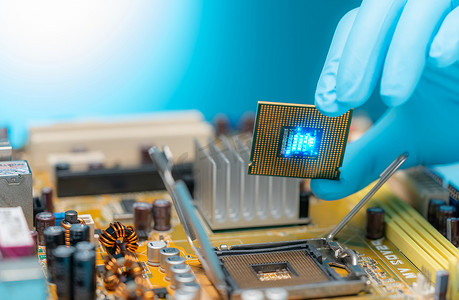 电子工程师手工将计算机芯片放在插座上。 