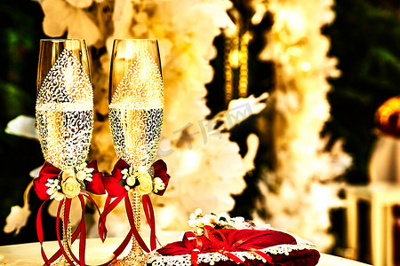 金色婚礼水晶香槟杯，配有红丝带和婚礼装饰