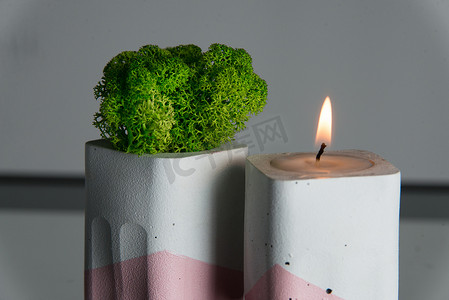 白色和粉色混凝土烛台中的蜡烛和苔藓