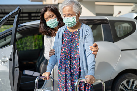 护理人员帮助和支持亚洲老年或老年老妇患者用助行器行走准备上车，健康强大的医疗理念。