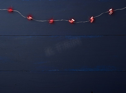 蓝色木坝上燃烧着小红靴子的圣诞花环