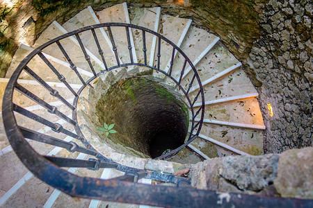 一条石制螺旋楼梯通向井底。