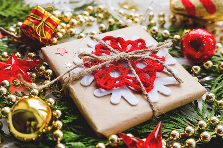 雪花新年摄影照片_圣诞节和新年背景与崖柏树枝、装饰品和用雪花牛皮纸包裹的礼物。