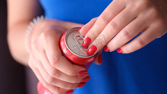 红指甲打开铁罐的女人，特写是饮料