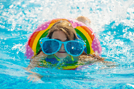 孩子游泳摄影照片_孩子正在游泳池里游泳。