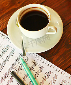 用笔在音乐笔记上热咖啡