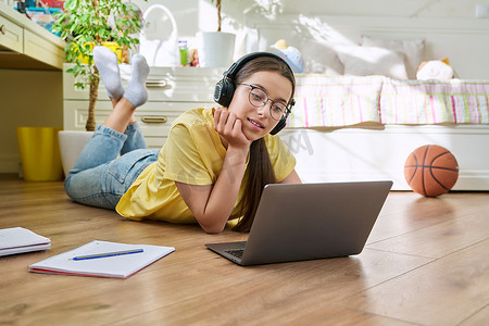 戴眼镜的少女在家使用笔记本电脑学习