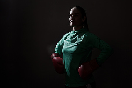 培训课件ppt摄影照片_穿着绿色运动服和红色拳击手套的拳击女子