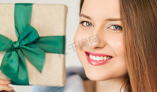 寒假、礼物和圣诞快乐的概念，快乐的女人微笑着拿着包装好的礼盒