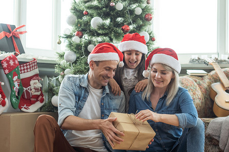 一家人在室内的圣诞树附近玩得开心和一起玩。