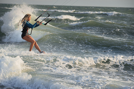 职业风筝冲浪者白人女子在大风天气中乘风破浪。