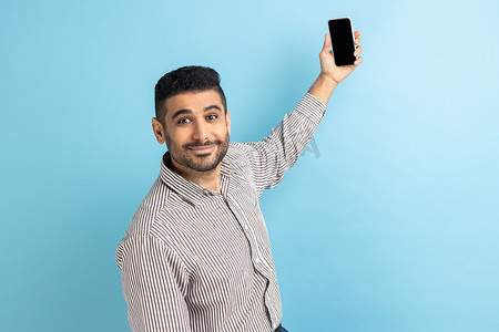 男子进行视频通话，用手机自拍，举起带有模型空白显示屏的智能手机