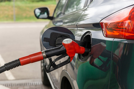 加油站小汽车摄影照片_在加油站为汽车加油的燃油喷嘴。