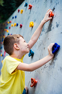 男孩在攀岩墙上玩耍