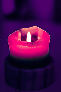 情人节紫色背景摄影照片_紫色背景的粉色节日蜡烛、圣诞节、除夕和情人节的奢侈品牌设计和装饰