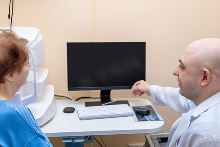 一位男性眼科医生向一位成年女性解释眼部检查的结果，并在电脑上展示了一张图