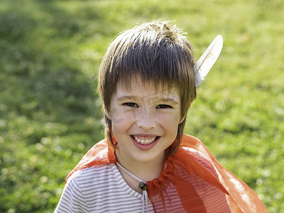 美国印第安人摄影照片_扮演美洲印第安人的微笑男孩的画像。