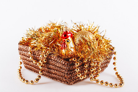 盒子里的金色玻璃公鸡，配有闪亮金属片和小珠。